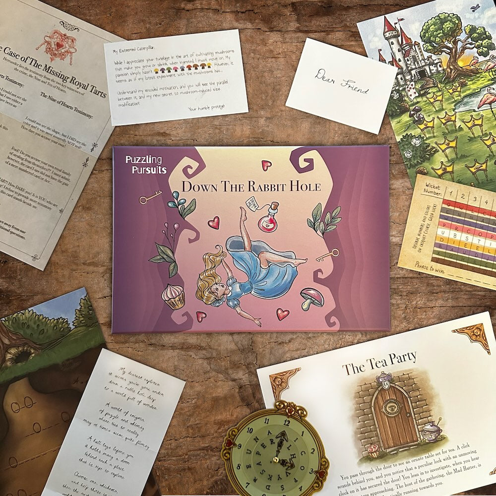 The Down The Rabbit Hole box with its game materials spread around it: Wonderland letters, a castle illustration, a green cipher wheel and a coloured wicket grid