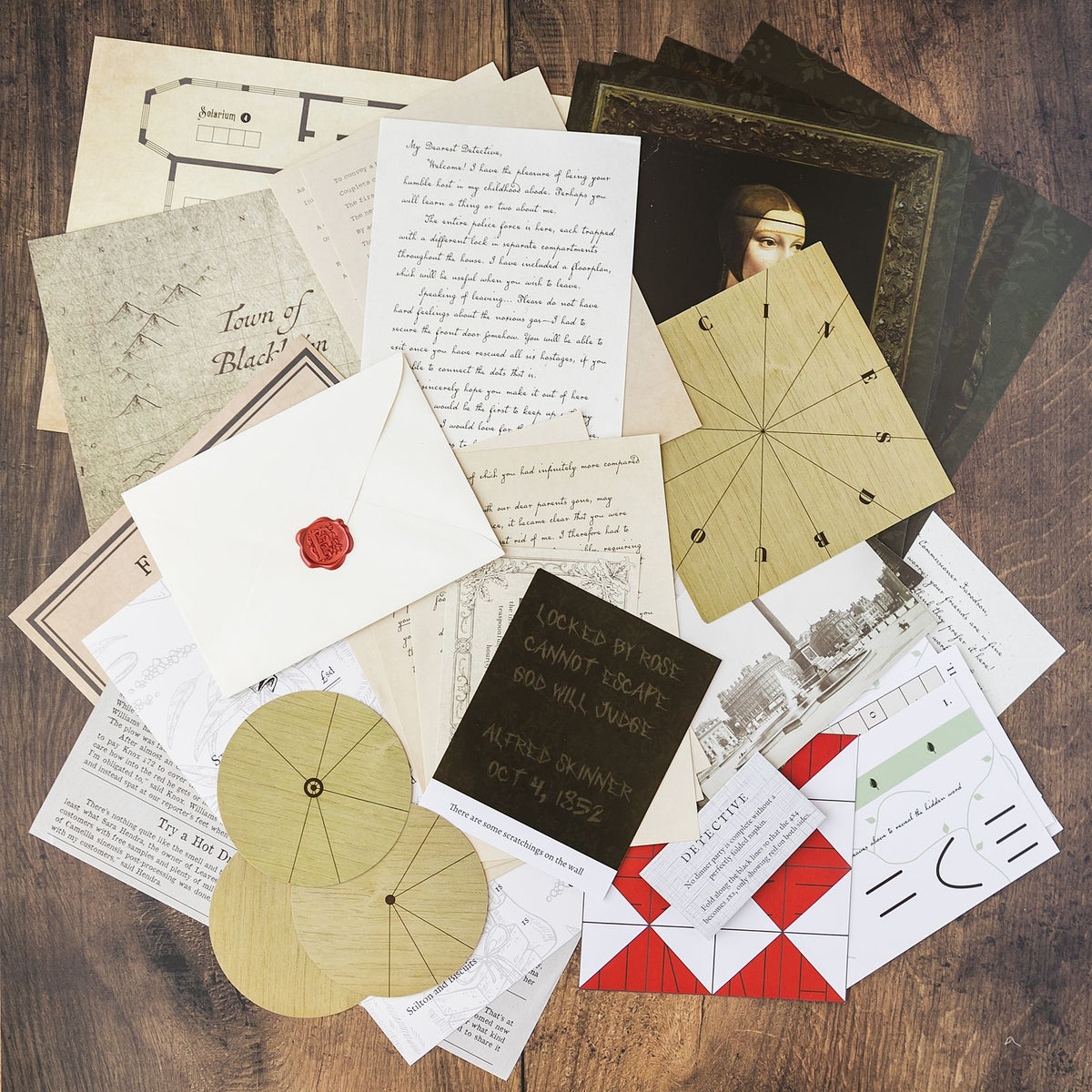 An at-home escape room game laid out on a wooden table: a town map, handwritten letters, a wax-sealed envelope, photographs and wooden cipher wheels