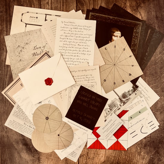 Blackbrim: 1876 components spread on a dark wood table: a Town of Blackbrim map, handwritten letters, a cream envelope closed with a red wax seal, wooden cipher wheels, photographs and newspaper pages