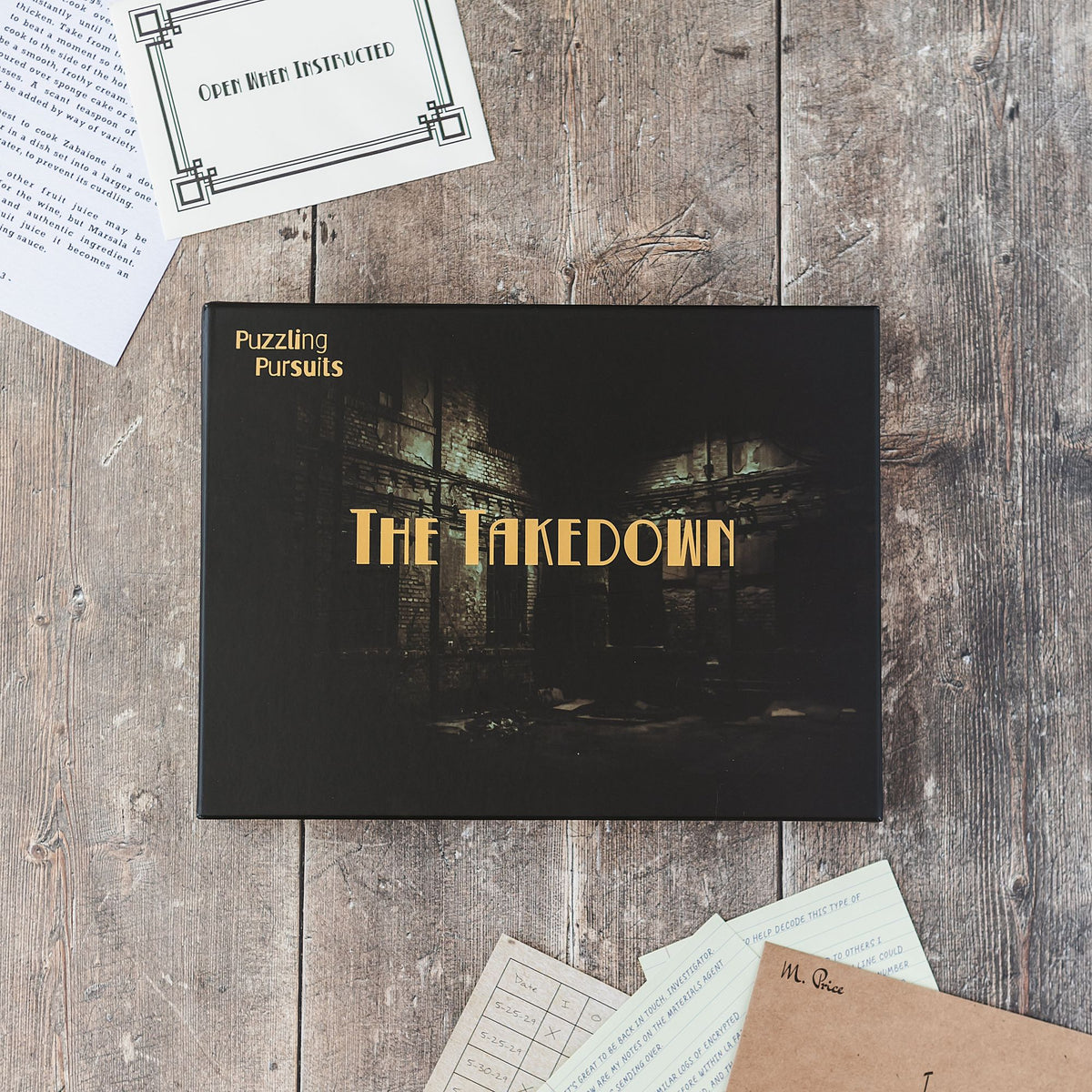 The Takedown game box with materials on a wooden table
